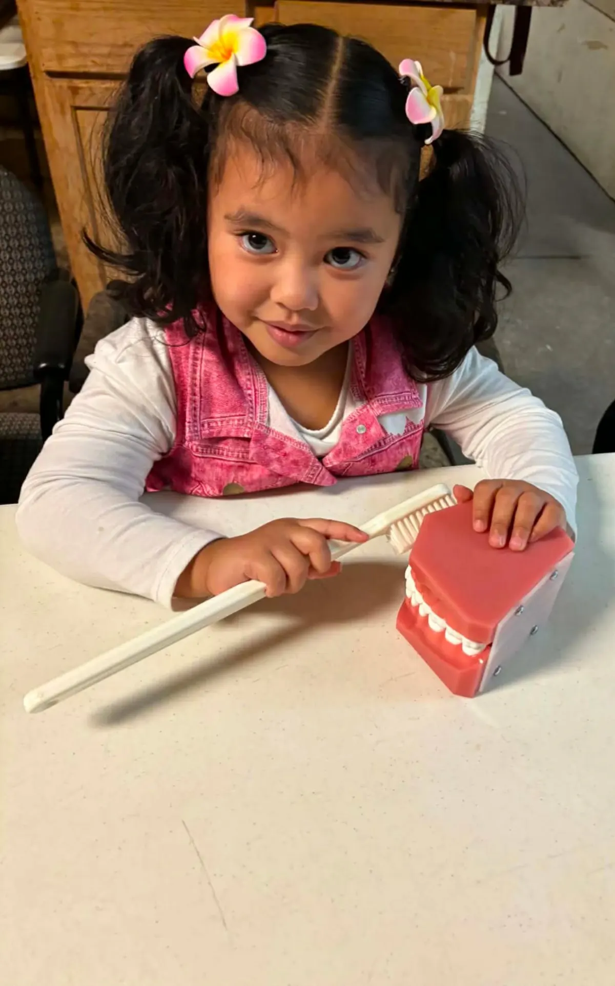 Child learning to brush with a dental model